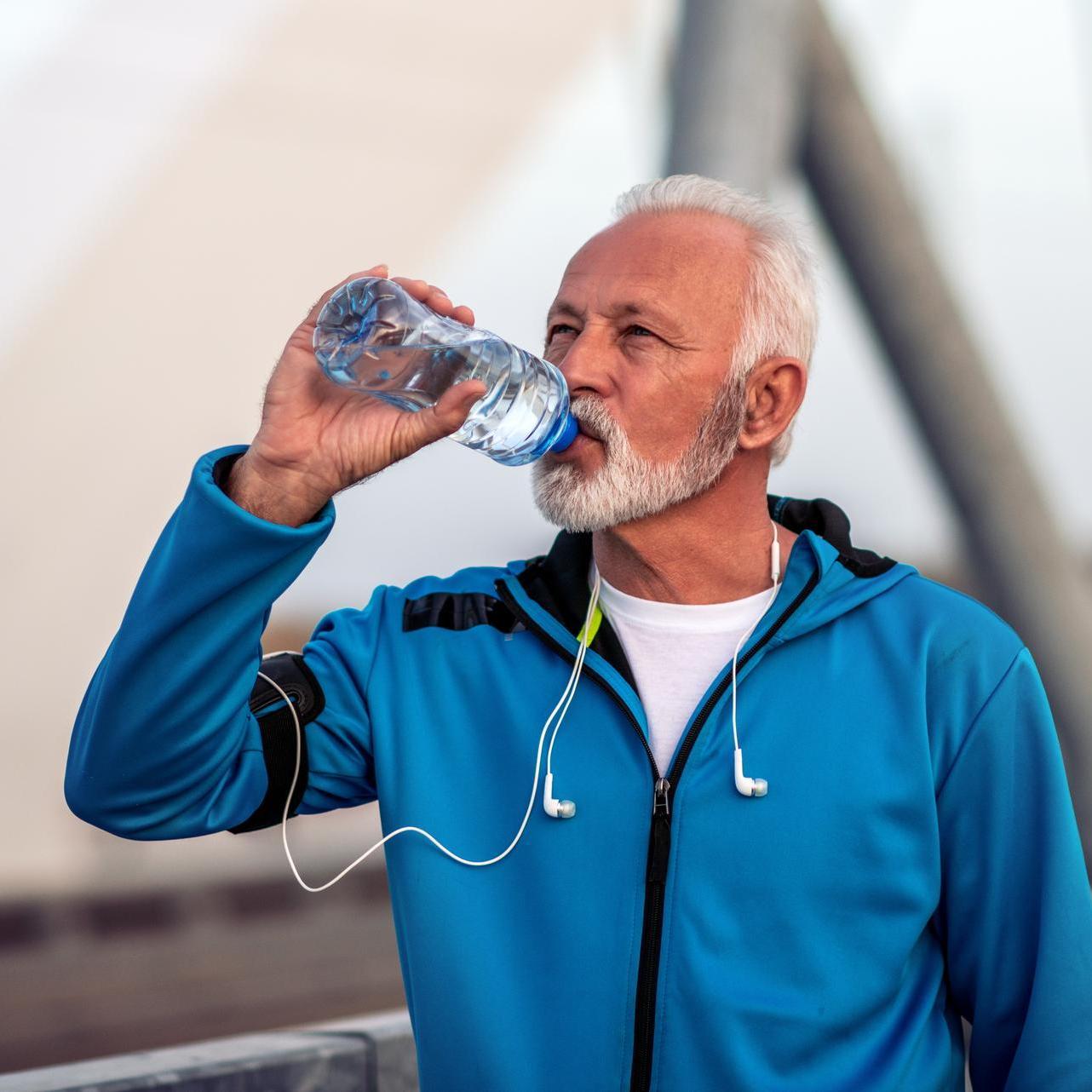 Mann trinkt aus Wasserflasche